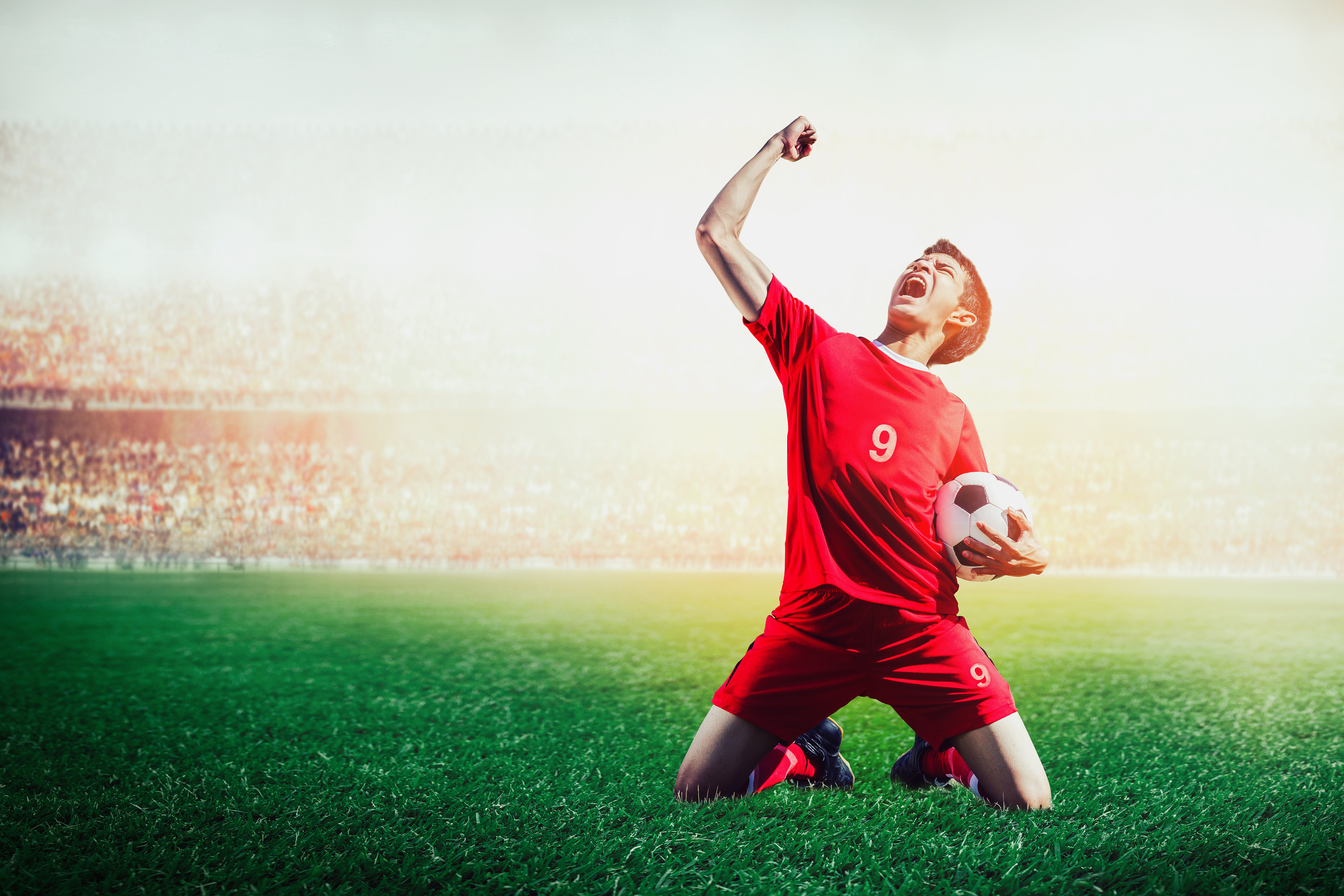 Soccer striker celebrating after scoring a goal during a stadium match